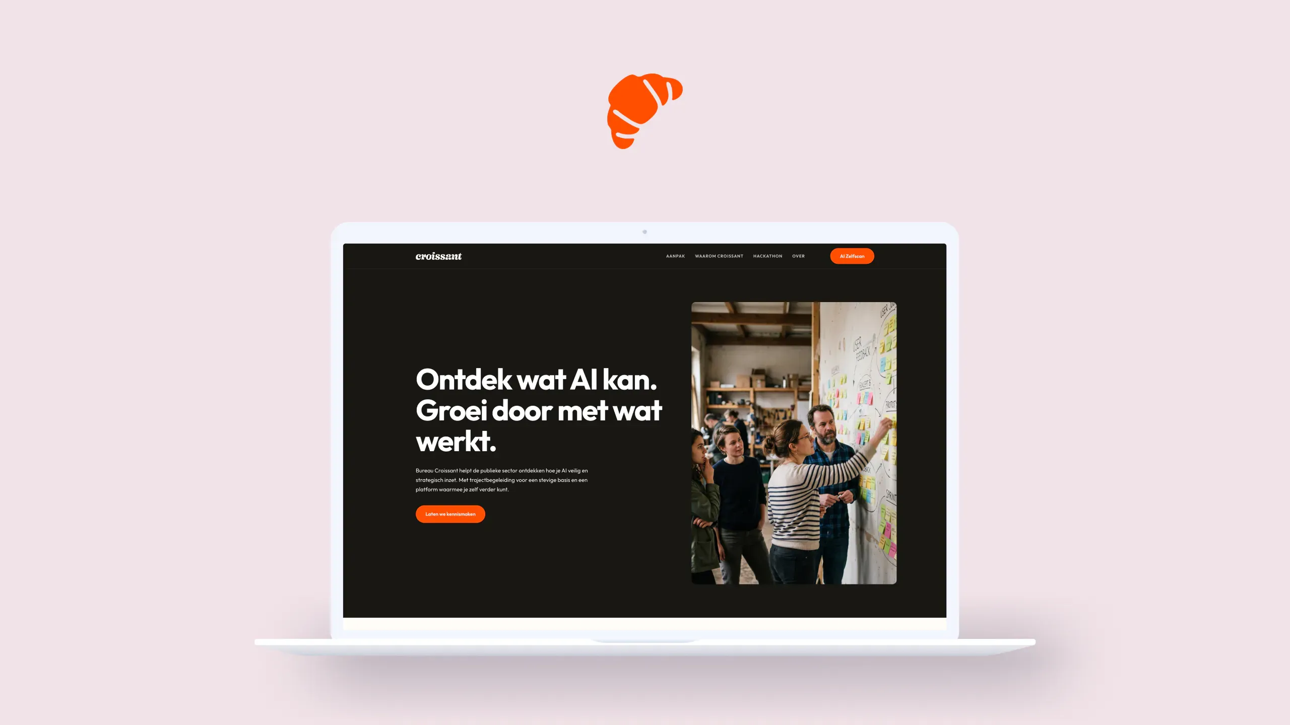 Bureau Croissant website in a laptop mockup on a light pink background — the dark homepage with an orange croissant icon floating above the screen
